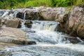 Waterfall cascades flowing over flat rocks in forest