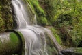 A waterfall cascading over an old power station pipe in the New Zealand forest Royalty Free Stock Photo