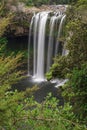 Long exposure of a waterfall in rocky countryside surrounded by forest