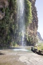 Waterfall on closed old road on the edge of rocky cliff between Ponta do Sol and Jardim do Mar, Madeira island, Portugal Royalty Free Stock Photo