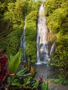 Waterfall with crystal blue water and rainbow in tropics. Jungle cascade waterfall in tropical rainforest with rock and turquoise