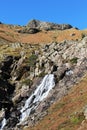 Waterfall down rocky outcrop on hillside, Cumbria