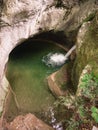 Waterfall at the entrance to a natural cave in the rock. Royalty Free Stock Photo