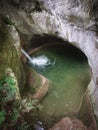 Waterfall at the entrance to a natural cave in the rock. Royalty Free Stock Photo