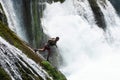 waterfall extreme brave man as superhero running jump and dive from the rock into the wild river water.