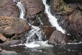 Waterfall falling into a lake with stones covered with moss in Halifax, Canada