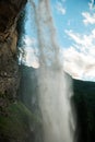 Waterfall flow in the mountains on blue sky background.stream of water with drops and splashes.Rushing water falls Royalty Free Stock Photo