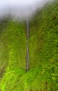 Waterfall flowing down green mountain, Na Pali Coast Wilderness Park, Kauai, Hawaii Royalty Free Stock Photo