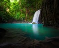 Waterfall flows into lake in forest and sunlight shines through