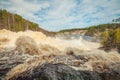 At the waterfall Girvas, Karelia. Russia. Arch of rainbow over the water