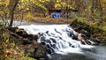 Waterfall and Graffiti Covered Building Hidden in the Autumn Forest Royalty Free Stock Photo