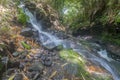 A waterfall that has mossy black stones Royalty Free Stock Photo
