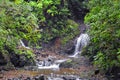 Waterfall Jaco Costa Rica, Catarastas Valle Encantado - Hidden waterfall surrounded by green trees, vegetation, rocks, leaves floa