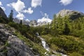 Waterfall at lake Seebensee on the path from Ehrwald village to Coburger Hut with mountain range in the background , Tyrol, Austri Royalty Free Stock Photo