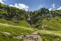 Waterfall at lakeTraualpsee on the popular hike to Landsberger Hut with mountain range in the background , Tyrol, Austria Royalty Free Stock Photo