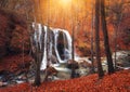 Waterfall at mountain river in autumn forest at sunset. Royalty Free Stock Photo