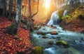 Waterfall at mountain river in autumn forest at sunset. Royalty Free Stock Photo