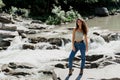 Waterfall in mountain river. Girl is travelling in Karpathian mountains and feeling freedom. Cascade waterfall and Royalty Free Stock Photo