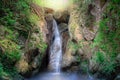 Waterfall on a mountain slope in deep forest. Tropical waterfall in rain forest. Royalty Free Stock Photo