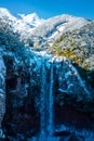 A waterfall on a mountain stream, spring meltwater flows in a mountain gorge, snow lies on the edges of a cliff and low Royalty Free Stock Photo