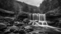 waterfall in the mountains black and white photo Waterfall panorama view in autumn with rocks and foliage.