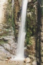 Waterfall in the mountains. Water falls from the mountain down to the rocks. It is photographed on an excerpt.