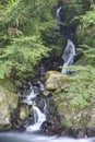 A waterfall in a mysterious forest with sunlight shining through the greenery Royalty Free Stock Photo