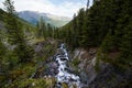 The waterfall noisily rushes down from the high mountains of Altai