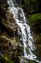 Waterfall over green mossy rocks