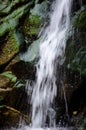 Waterfall over green mossy rocks