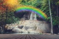Waterfall with rainbow and wooden floor