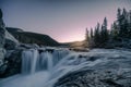 Waterfall rapids flowing on rocks in pine forest on evening at Elbow falls