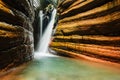 waterfall in the red canyon with layers of red rocks in a forest in austria Royalty Free Stock Photo