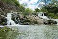 The waterfall on the river flows through and over the rocks cove Royalty Free Stock Photo