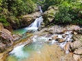 Waterfall with big rock bank in the green tropical forest