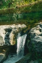 Small waterfall. Mountain river. Water falls from a stone cliff. Royalty Free Stock Photo