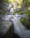 Waterfall between rocks fallen from unknown places. Royalty Free Stock Photo