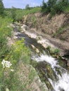 Waterfall in the rocks the stream flows among the stones in the summer