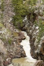 Waterfall in rocky ravine with melting snow Royalty Free Stock Photo