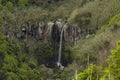 Waterfall Salto da Farinha falling from rocks in lush green rainforest vegetation, Sao Miguel island, Azores, Portugal