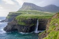 A waterfall sits at the edge of a micro town in the cold arctic