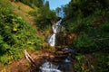 Waterfall among stones and taiga driftwood in water and wet stones Royalty Free Stock Photo