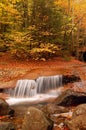 A waterfall surrounded by fall foliage Royalty Free Stock Photo