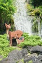 Waterfall and toy lego deer sculptures Royalty Free Stock Photo
