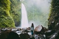 Waterfall in tropical jungle and alone woman. Waterfall in Bali Royalty Free Stock Photo