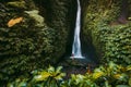 Waterfall in tropical jungle and alone woman in bikini. Leke Leke waterfall in Bali Royalty Free Stock Photo