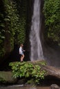 Waterfall in tropical jungle and alone woman tourist. Leke Leke waterfall in Bali, Indonesia Royalty Free Stock Photo