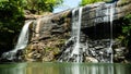 Waterfall among tropical jungle with green plants and trees. Sri Lanka.