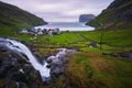 Waterfall and the village of Tjornuvik in the Faroe Islands