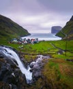 Waterfall and the village of Tjornuvik in the Faroe Islands